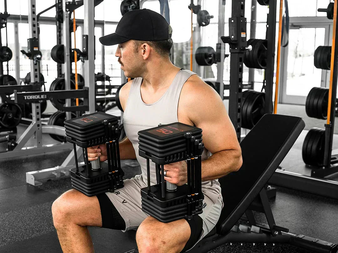 person using powerblock adjustable dumbbells the fitness outlet