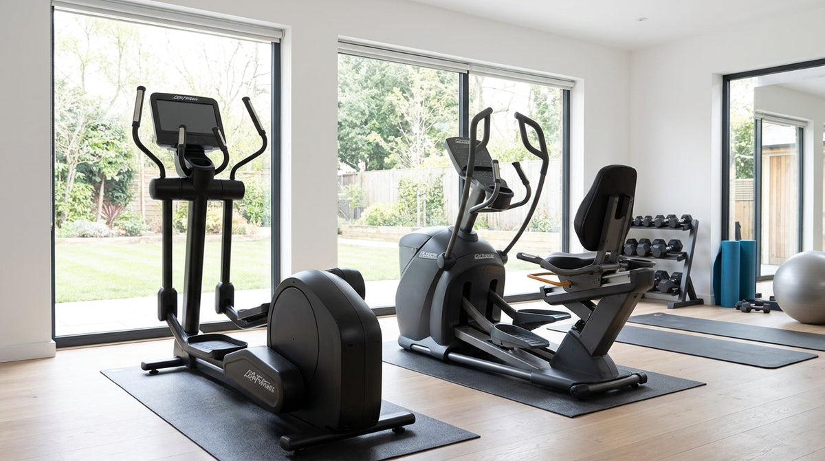 Bright home gym featuring a standing elliptical and a seated elliptical beside large windows